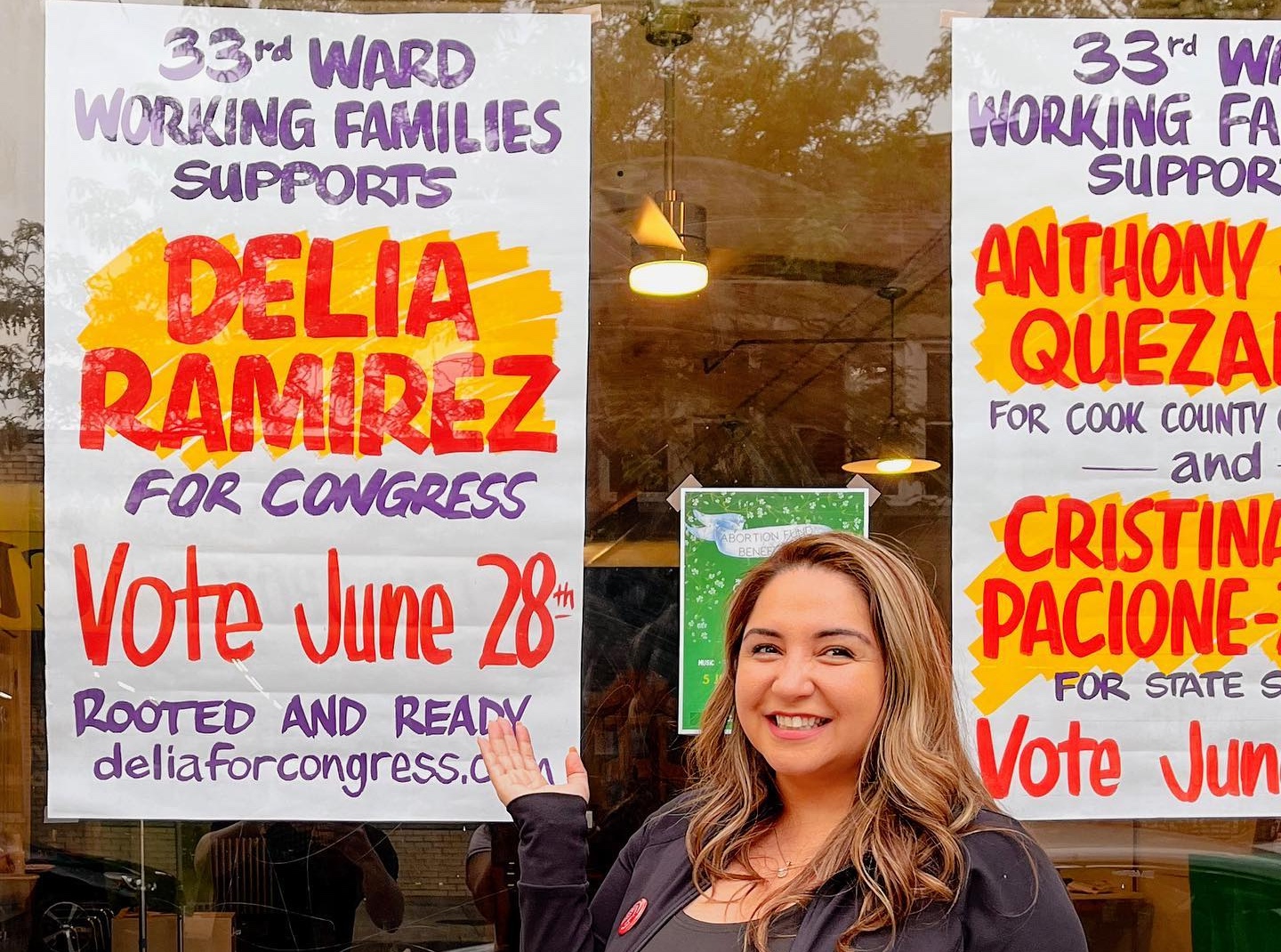 Delia Ramirez standing by 33WF campaign poster